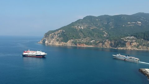 Skopelos, Greece - November 2019: Express Skiathos Ferry boat from Hellenic Seaways crossing by Proteus Ferry boat from Anes lines outside the port of Skopelos island in Chora, Sporades, Greece