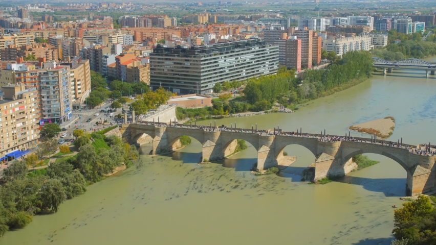 Aerial View Of People Crossing At Puente de Piedra (Stone Bridge) Over Ebro River In Zaragoza, Aragon, Spain.