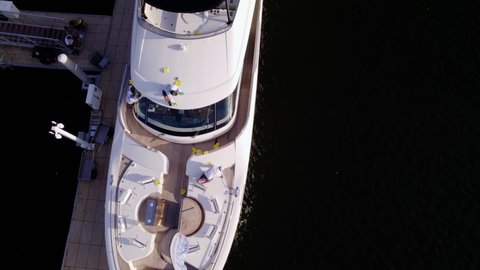 Aerial view above people cleaning a yacht, in Florida - screwdriver, drone shot