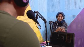 muslim woman recording podcast with a man in the studio