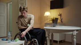 A young disabled man is making an exercise with dumbbells