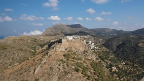 Aerial drone video of iconic medieval castle of main village of Kithira island overlooking beautiful double bay and beach of Kapsali, Kythira island, Ionian, Greece