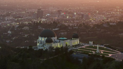Los Angeles, California, circa 2019: Amazing view of the Griffith Observatory in Mount Hollywood. Beautiful sky during sunset. Crowded entrance lawn and observation deck. United States.
