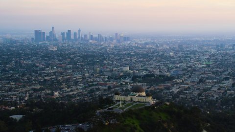 Los Angeles, California, USA. Circa 2019:
Great view of the Griffith Observatory in Mount Hollywood. Downtown skyline with its famous skyscrapers during sunset. 