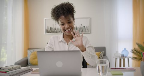 Young happy African American Woman Waving Hand Looking at Webcam Talking to Camera, Video Conference Call Virtual Chat Meeting at Home Office.