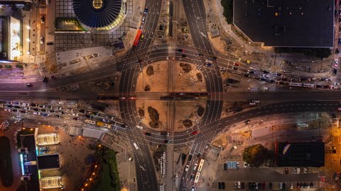 Aerial birds eye overhead top down view of large hybrid roundabout mixed with tram tracks junction. Night hyperlapse shot. Warsaw, Poland