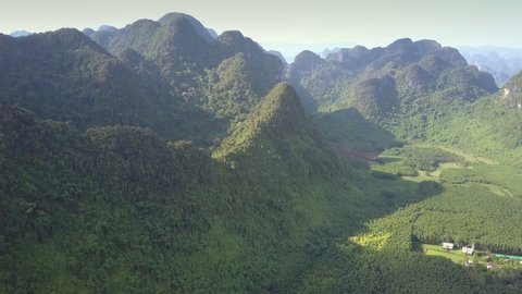 large old mountain hills covered with tropical jungle and pictorial valley against clear sky aerial view