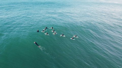Drone aerial shot of group of surfers and bodyboarders waiting in line-up Central Coast Reef Pacific Ocean NSW Australia 4K