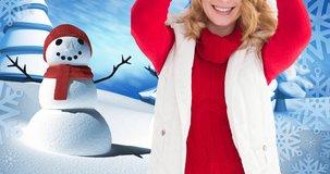 Animation of happy caucasian woman wearing santa hat keeping present over winter scenery. christmas, winter, tradition and celebration concept digitally generated video.