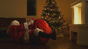 Santa Claus with bag of gifts crawls out of fireplace at Christmas or New Year. - Powered by Shutterstock - Get 15% off with code: PIKWIZARD15