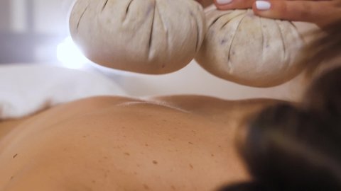 massage with herbal bags, close-up