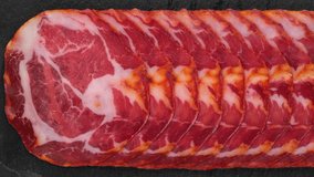 Sliced Spanish sausages Coppa or Capicola top view. Sliding shot. 4K UHD video 