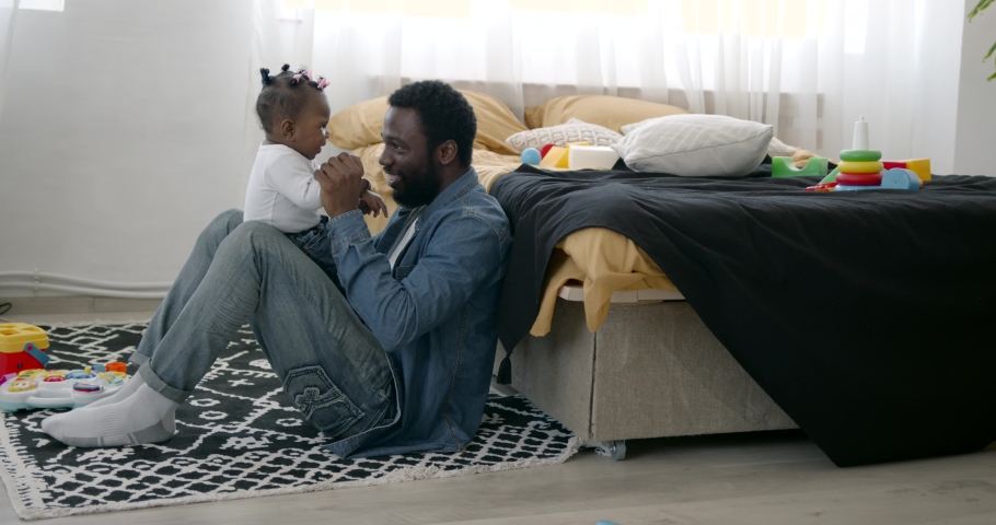 Dad and toddler daughter having fun playing at home