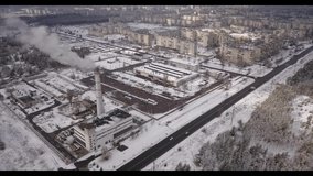 Video from drone of winter factory. Emission to atmosphere from industrial pipes near the town