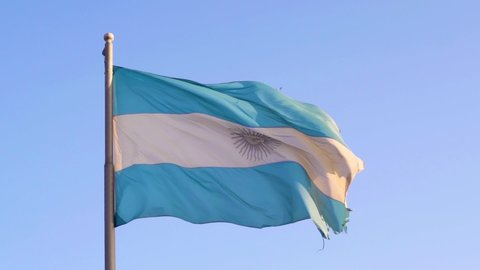 A closeup of an Argentinian flag waving on a blue sky background