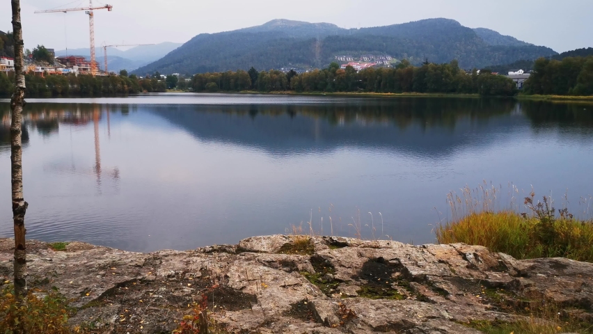 A beautiful clear lake with a reflection of the lush mountains around it