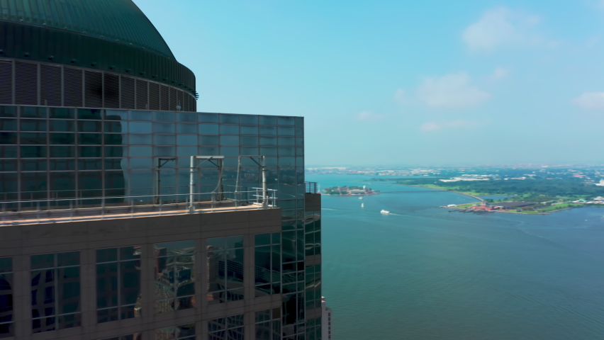 Helicopter flying fast around waterfront building at lower Manhattan, Wall street district with Hudson river and liberty island view in distance. Panoramic overview on World Trade center New York city Royalty-Free Stock Footage #1080791825