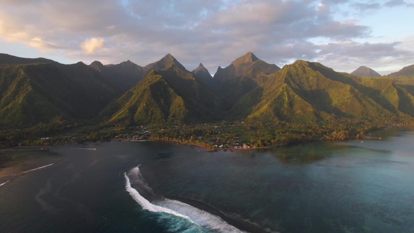 Flying over ocean coastal mountain landscape of Teahupoo, Tahiti. Sunset Drone aerial shot of waves and reefs. Sunrise Tropical paradise. French Polynesia 4k. Royalty-Free Stock Footage #1080803960