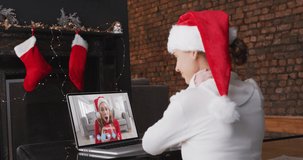 Animation of snow falling over smiling girl in santa hat making christmas video call with family. christmas, tradition and celebration concept digitally generated video.