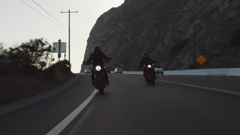 Cafe-racer bikers riding on modern retro motorcycles in Malibu by the ocean 