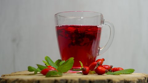 Rosehip red tea, homeopathic drink for human health. Red berry medicinal on a spinning table