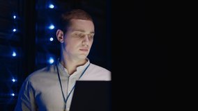 IT technician in data center digital server room controlling work of rack server cabinets with a tablet. Professional server engineer at work. Man technicians working in high tech server rack room - Powered by Shutterstock - Get 15% off with code: PIKWIZARD15