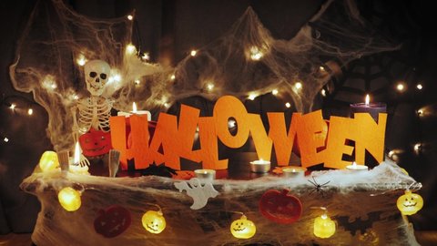 Halloween decorations in lights at night. Halloween party background with pumpkins and halloween characters. Happy halloween. Celebrating traditional autumn holidays