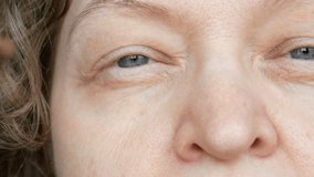 middle-aged woman does corrective eye makeup to correct the drooping eyelid. Ptosis is a drooping of the upper eyelid, lazy eye. Cosmetology and facial concept
