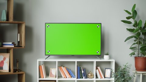 Television with green screen close-up. Chroma key on tv set in modern living room. Horizontal mock-up, domestic cinema concept. 