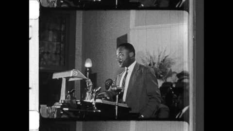 1956 Montgomery, AL. Martin Luther King Jr. address crowd and calls off The Montgomery Bus Boycott after City agrees to desegregate the Bus Lines. Audience applauds the victory. 4K Overscan of Film 