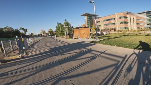 Fort Collins, CO, USA - October 16, 2021: Riding bike on a paved trail in Fort Collins, Colorado, POV in fall scenery with a cyclist shadow and a city bus passing by