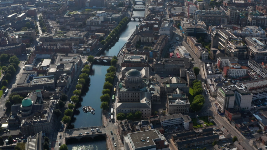 Aerial view of historic buildings with domes on riverbanks. Traffic on bridges across Liffey river. Dublin, Ireland