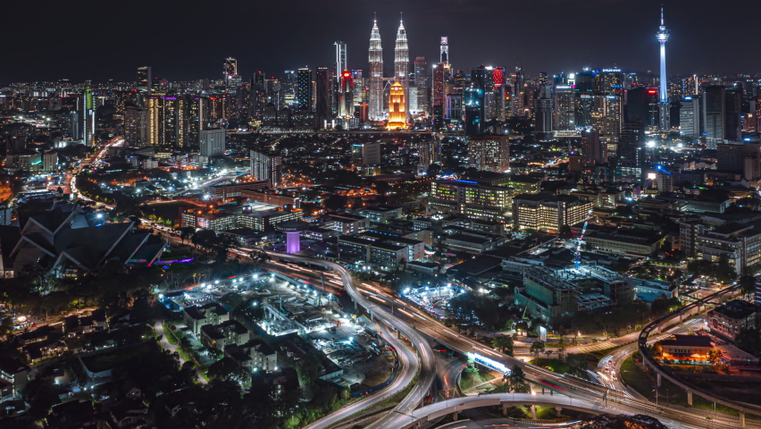 Malaysia Time lapse: Aerial city during night overlooking Kuala Lumpur city skyline and the Kuala Lumpur General Hospital with busy roundabout and streets. Tilt up motion timelapse. Prores 4K Royalty-Free Stock Footage #1080850925