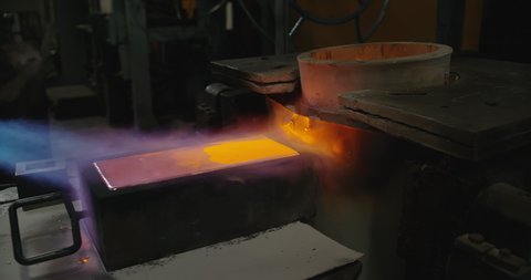 Metal gold bars at Production Industrial Line at non ferrous production plant. Work Shop. Factory Worker Uses Fire to Compress Ingot With Gold. Gold Bars Production, Precious Hot bars. Processing line