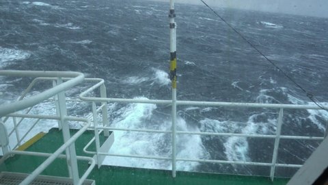 Ship in storm. View from bridge. Ship climb up wave. Splashes. Salt water on window. Strong pitching. High waves hit ship. White foam on water.