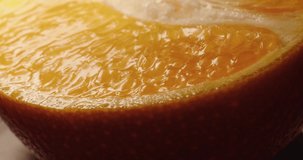 Macro video filming of an orange slice. Orange slice close-up. Ripe orange close-up. Black Magic. 4k