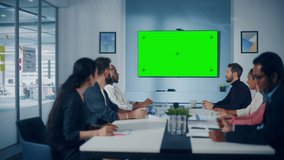 Multi-Ethnic Office Conference Room Meeting: Diverse Team of Successful Managers, Executives Talk, Use Green Screen Chroma Key TV. Group of Businesspeople Work on Strategy for an e-Commerce Startup
