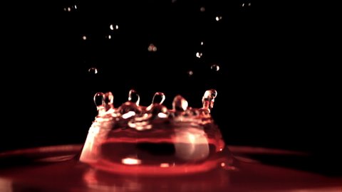 Super slow motion drop of wine falls with splashes into the glass. On a black background.Filmed on a high-speed camera at 1000 fps. High quality FullHD footage
