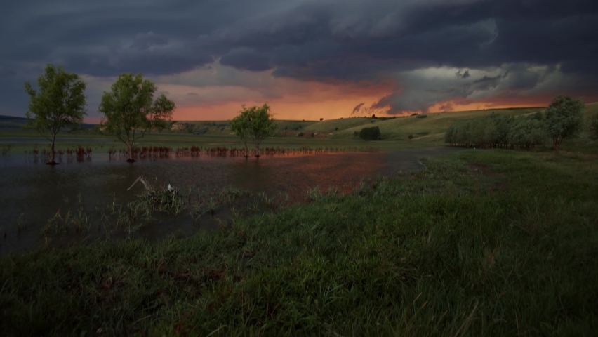 Picturesque storm clouds over the green field in summertime. Agricultural area of Romania, Europe. Force of nature