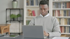 African Man Talking on Video Call on Laptop in Library