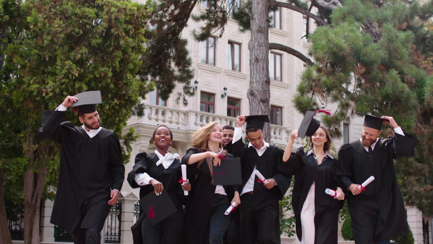 Excited multiracial students graduates happy throw up the graduation caps in the college garden they are feeling great all together Royalty-Free Stock Footage #1080894002
