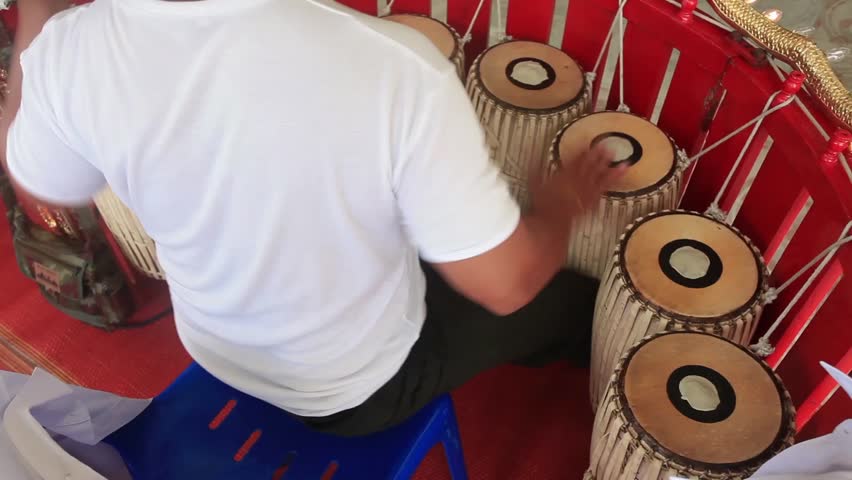 A man hit the Gong ancient drums with Thai Musical Instrument.