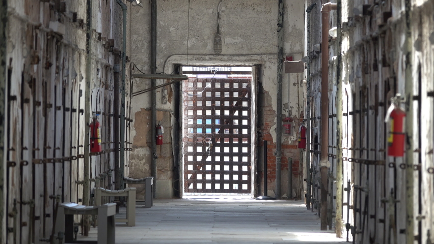Barred door and fire extinguishers in penitentiary cell block.