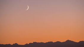 shining half-moon in the clear sky in a yellow colorful night. moonlight shines in wide space sky. timelapse 4k of lunar traveling in the heaven. outdoor light in brightening the sky.  - Powered by Shutterstock - Get 15% off with code: PIKWIZARD15
