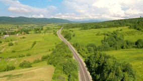 Majestic view from a drone flying over a road passing through a mountain pass. Carpathian mountains, Ukraine, Europe. Cinematic aerial shot. Explore the beauty of world. Filmed in 4k, drone video.