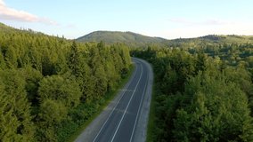 Majestic view from a drone flying over a road passing through a mountain pass. Carpathian mountains, Ukraine, Europe. Cinematic aerial shot. Discover the beauty of earth. Filmed in 4k, drone video.