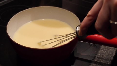 Making cheese fondue in a kitchen. Delicious cooking.
