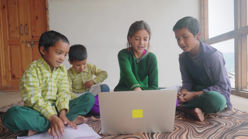 shot of A young girl is teaching a group of Indian Asian primary school children or kids sitting and studying together using a laptop in an indoor classroom setup. learning and education concept Royalty-Free Stock Footage #1080914462