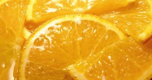 Water drops fall on orange slices. Drops of water fall on orange slices. Orange slices are poured with water drops. The video was filmed with a Black Magic movie camera. 4k
