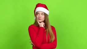 Teenager girl with christmas hat standing and thinking an idea pointing the finger up over isolated background